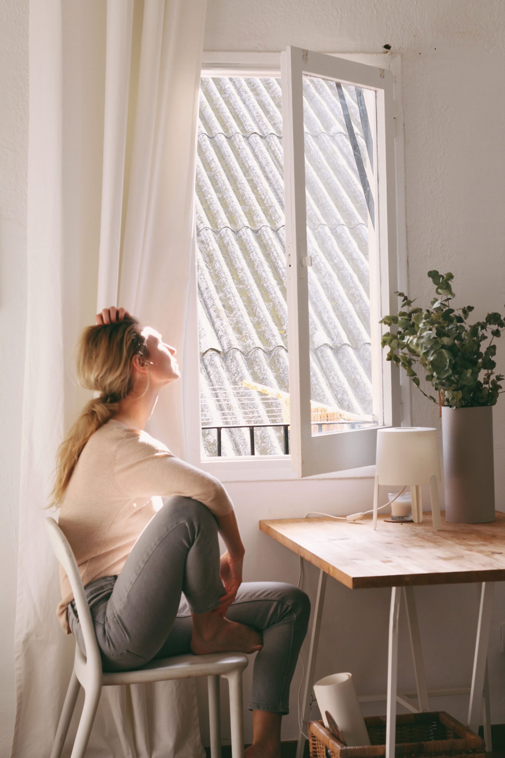 Femme pensive à table en famille, qui retrouve sa place sans culpabiliser.